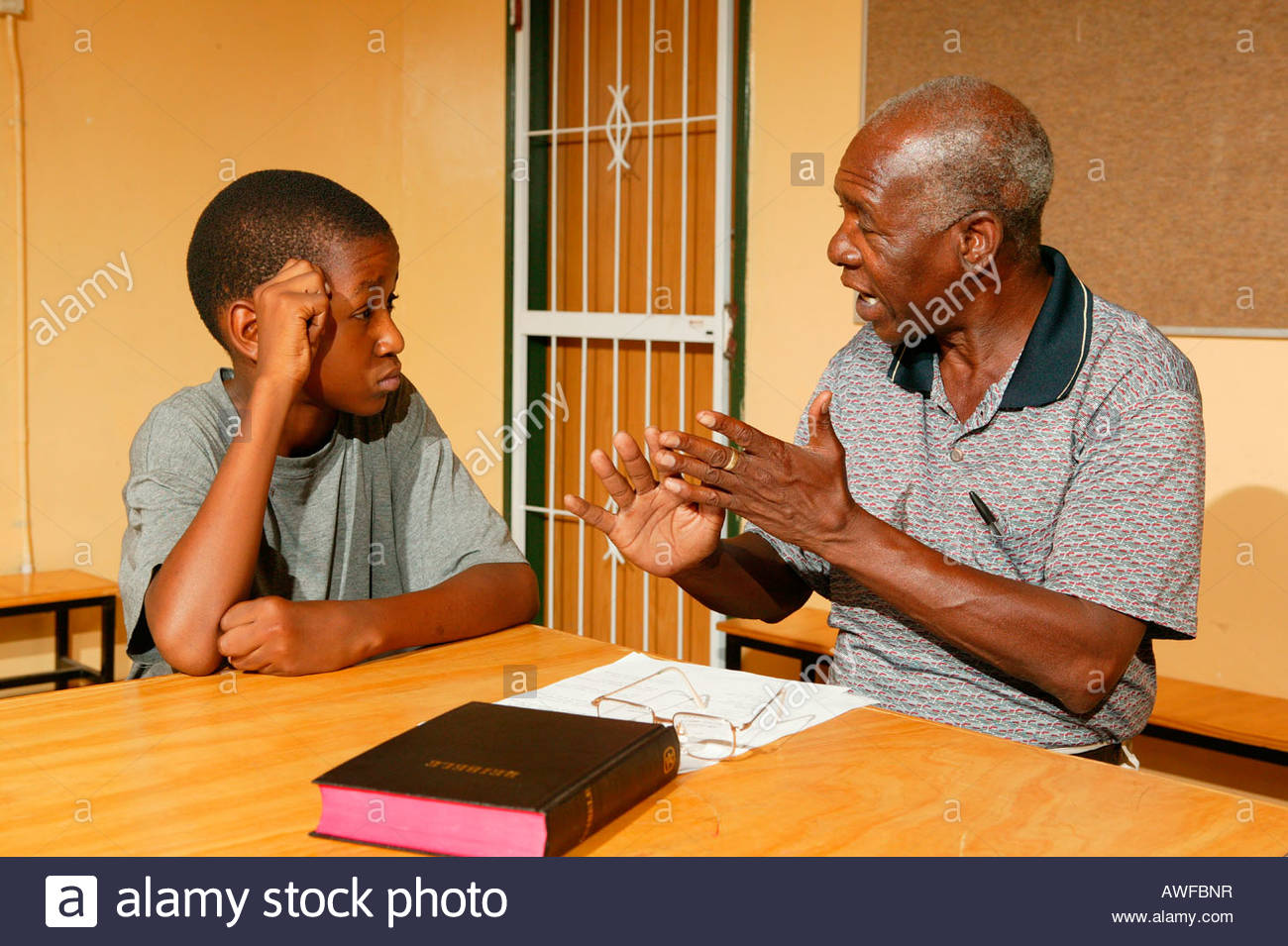 elderly-man-and-teenager-having-a-conversation-during-a-bible-class-AWFBNR.jpg