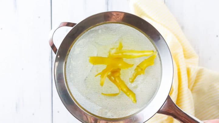 Straining peels out of lemon simple syrup.