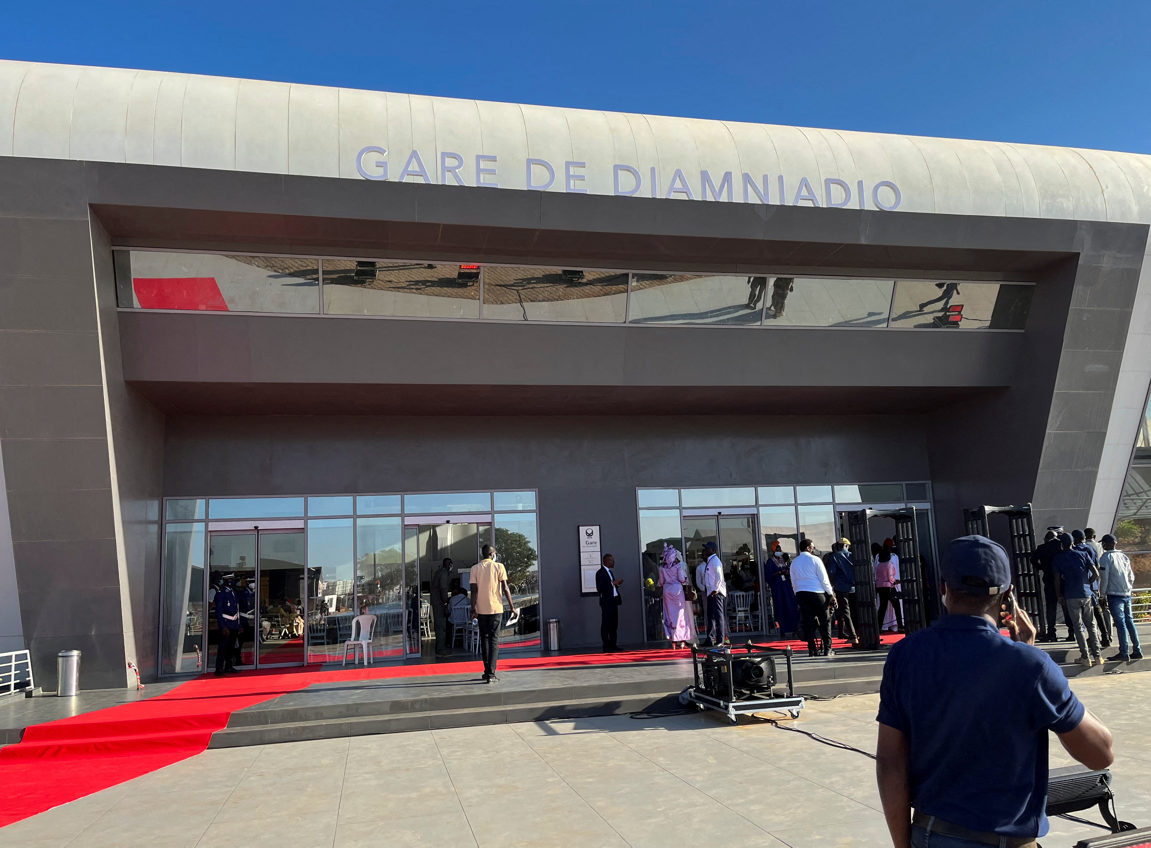 People stand at the entrance of Senegal's new commuter train station during the launch ceremony of the Regional Express in Diamniadio, Senegal, December 27, 2021. REUTERS/Elodie Toto