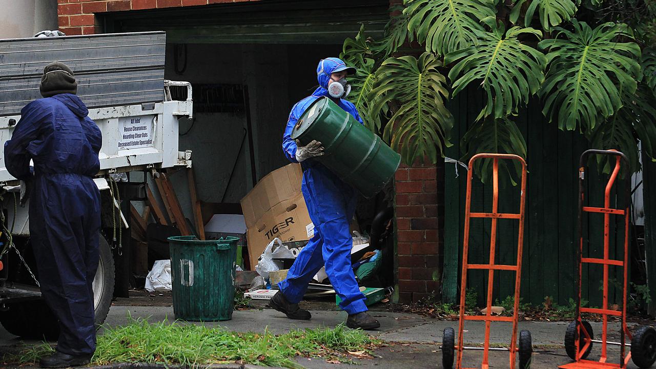 Toxic debris is cleared from the house where two dead men lay decomposing.