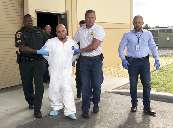 Quadruple murder suspect Bryan Riley is led from the Polk County Sheriff’s Office in Lakeland, Fla., on Sunday, Sept. 5, 2021, by Deputy Steve Neil, left, Captain Bart Davis and Detective Brett Bulman. (Kimberly C. Moore/The Ledger via AP)