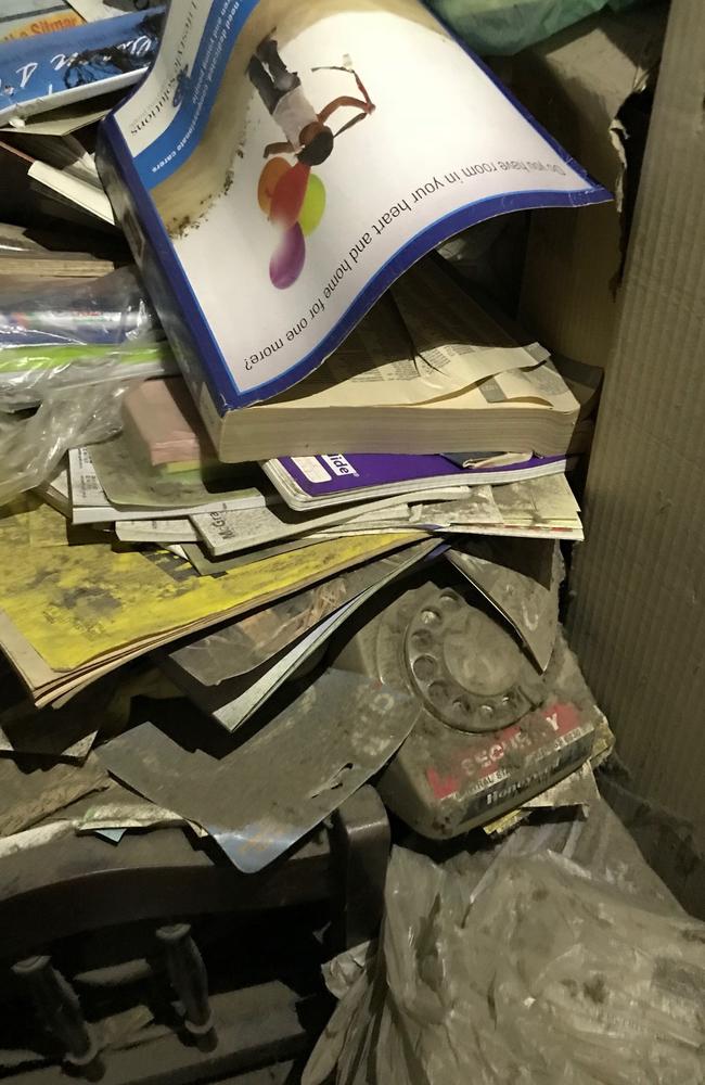 Phone book and other items stacked up in a filthy corner of hoarder Bruce Roberts’ Greenwich home in which he murdered Shane Snellman.