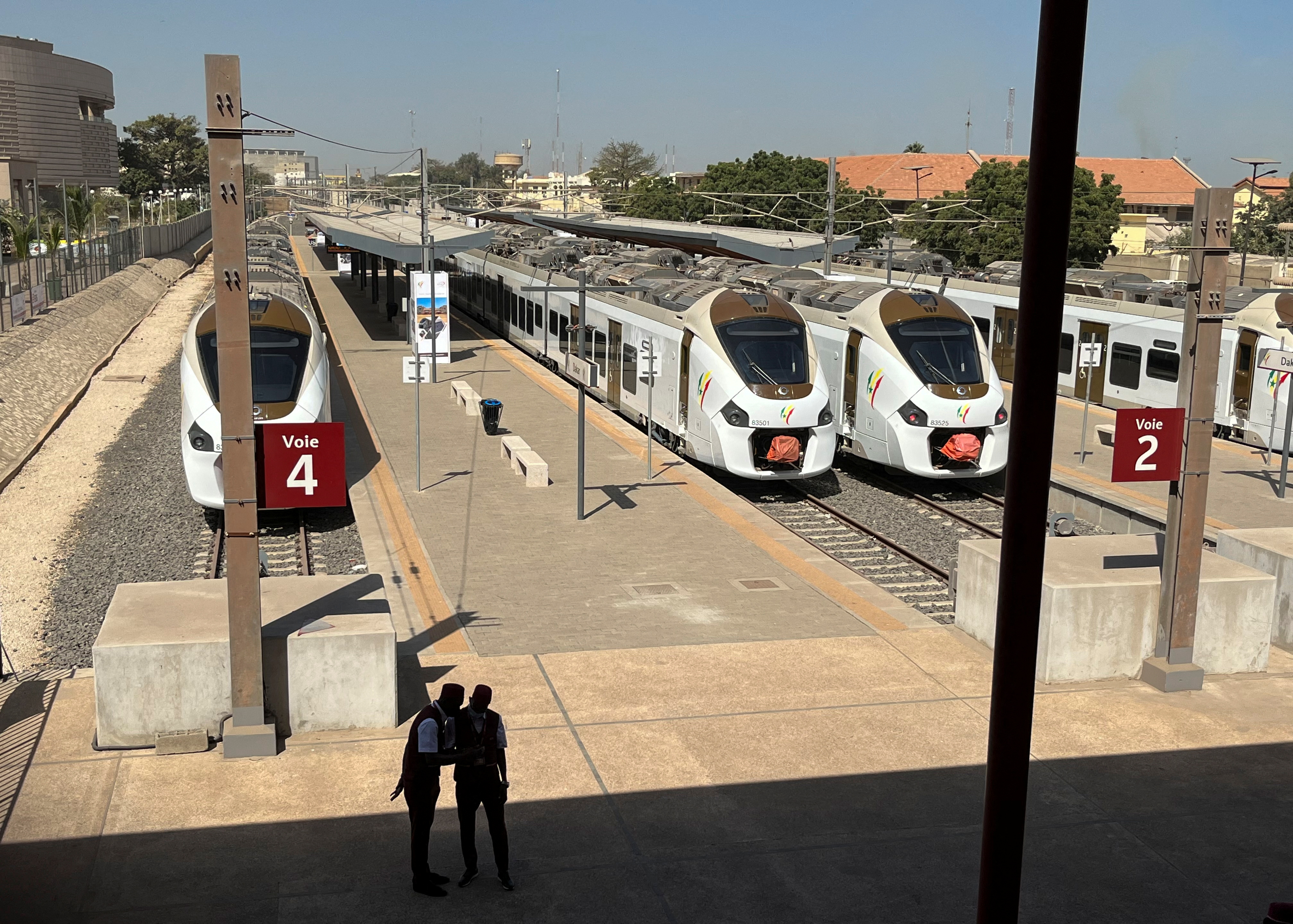Workers stand at a platform next to Senegal's new commuter trains at a train station during the launch ceremony of the Regional Express in Dakar, Senegal, December 27, 2021. REUTERS/Elodie Toto